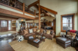 This stunning mountain home boasts a spacious open floor plan with soaring ceilings and exposed wooden beams.