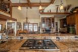 This stunning kitchen boasts a large granite island with a built-in gas cooktop, perfect for entertaining.
