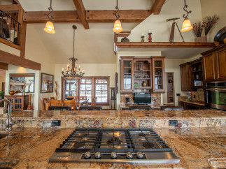 This stunning kitchen boasts a large granite island with a built-in gas cooktop, perfect for entertaining.