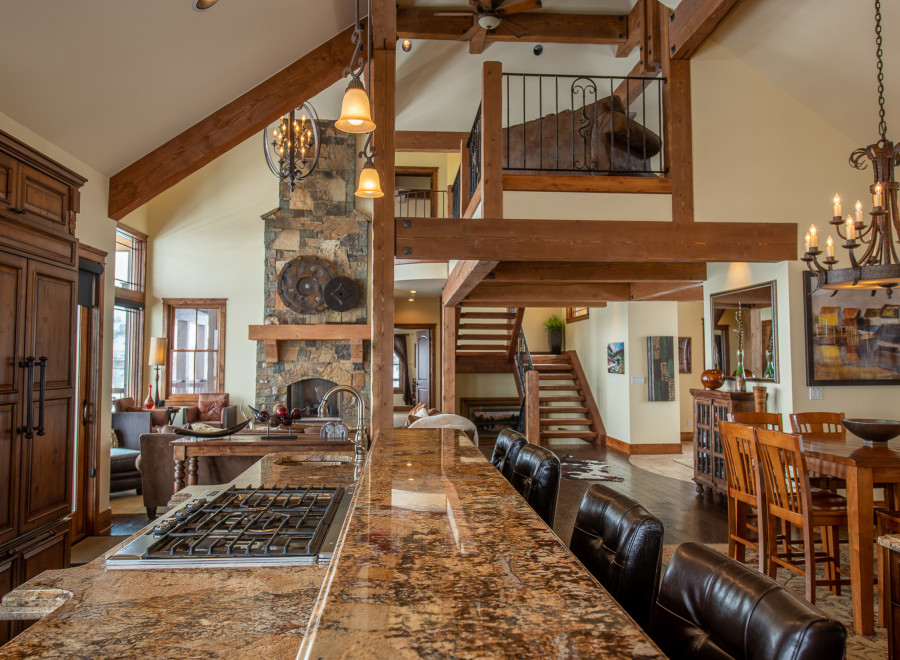 This stunning home boasts a spacious open floor plan with high ceilings and exposed wooden beams, creating a warm and inviting atmosphere.