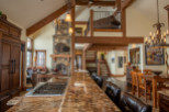 This stunning home boasts a spacious open floor plan with high ceilings and exposed wooden beams, creating a warm and inviting atmosphere.
