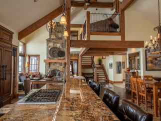 This stunning home boasts a spacious open floor plan with high ceilings and exposed wooden beams, creating a warm and inviting atmosphere.