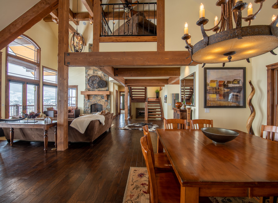 This stunning home boasts a spacious open floor plan with soaring ceilings and exposed wooden beams, creating a warm and inviting atmosphere.