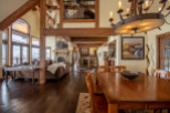 This stunning home boasts a spacious open floor plan with soaring ceilings and exposed wooden beams, creating a warm and inviting atmosphere.