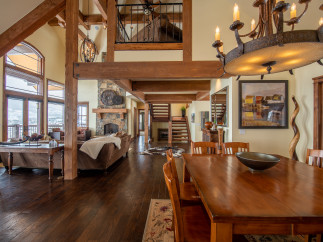 This stunning home boasts a spacious open floor plan with soaring ceilings and exposed wooden beams, creating a warm and inviting atmosphere.