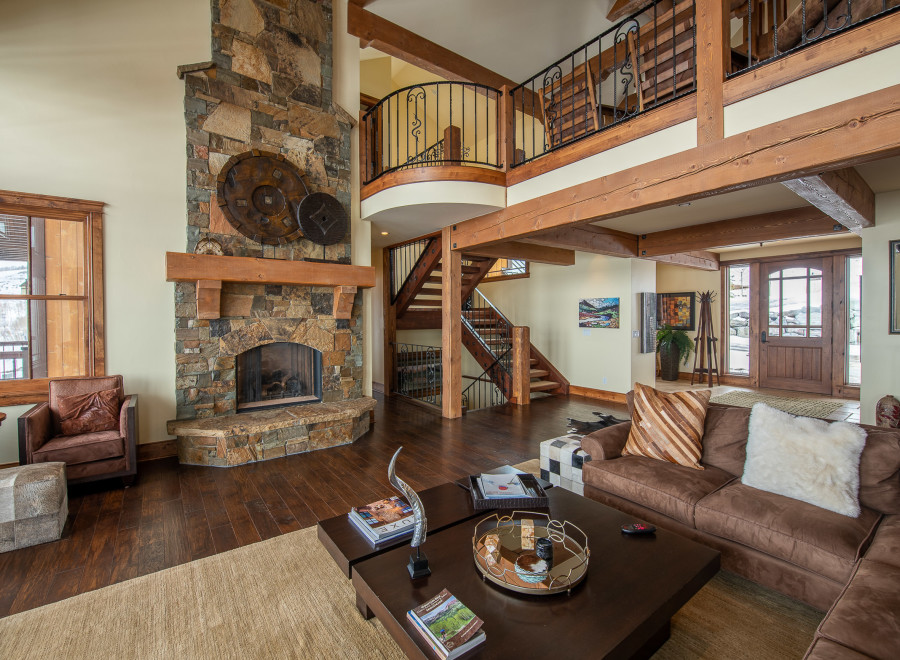 This stunning mountain home boasts a spacious open floor plan with soaring ceilings and exposed wooden beams.