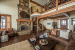 This stunning mountain home boasts a spacious open floor plan with soaring ceilings and exposed wooden beams.