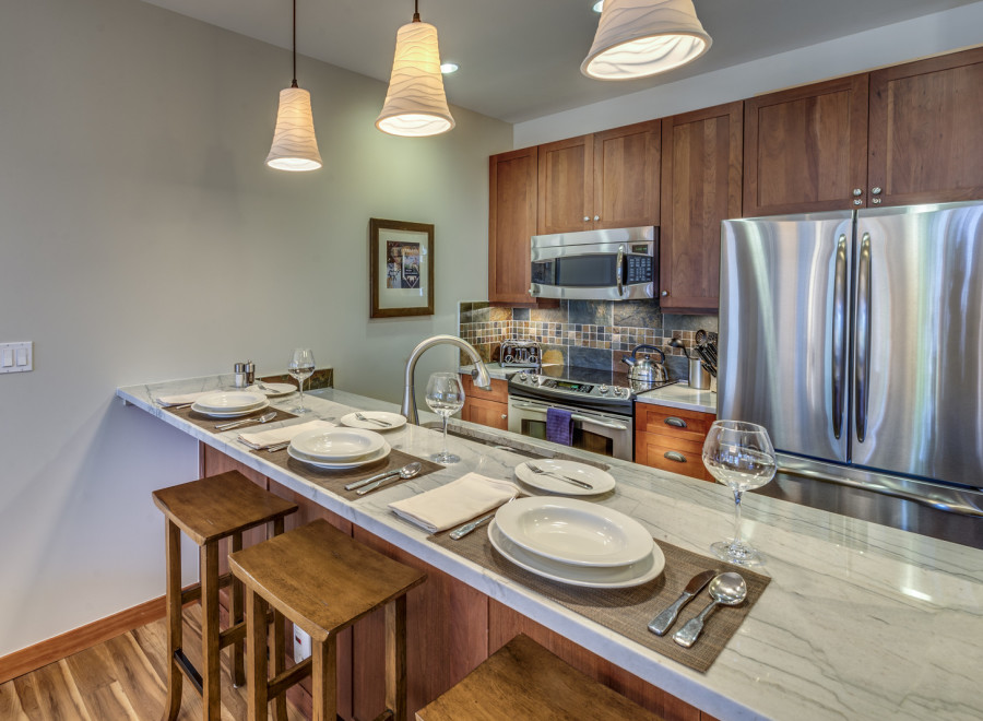 This stunning kitchen boasts a modern design with a sleek marble countertop and elegant pendant lighting.