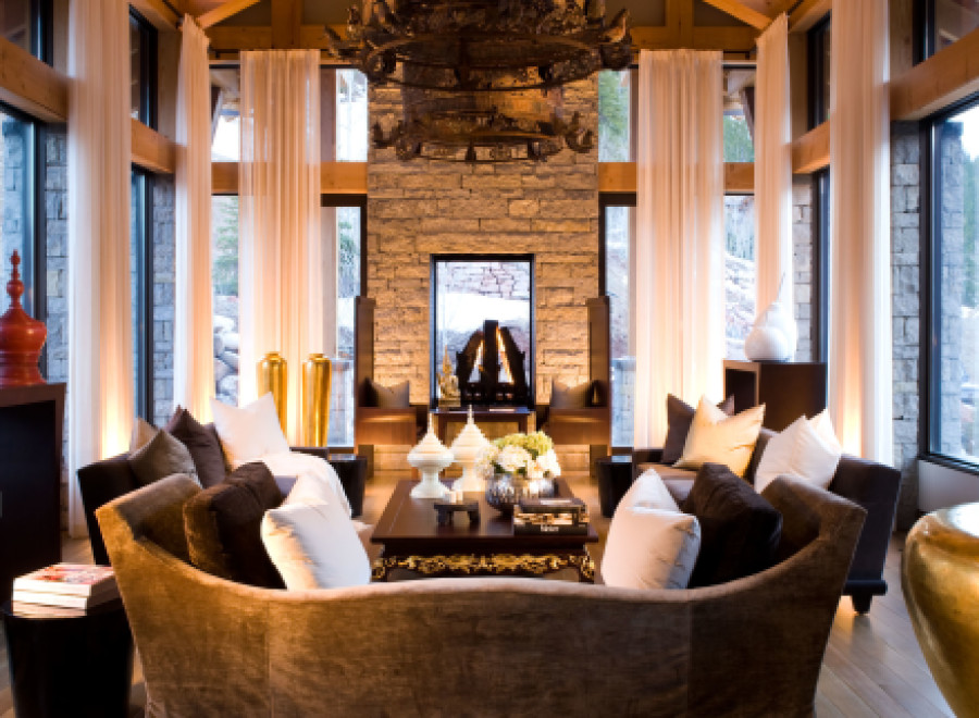Experience luxury living in this stunning property, featuring a grand living room with a vaulted ceiling and exposed wooden beams.