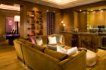 This luxurious living space features a cozy, mustard-colored sectional sofa, perfect for relaxation.