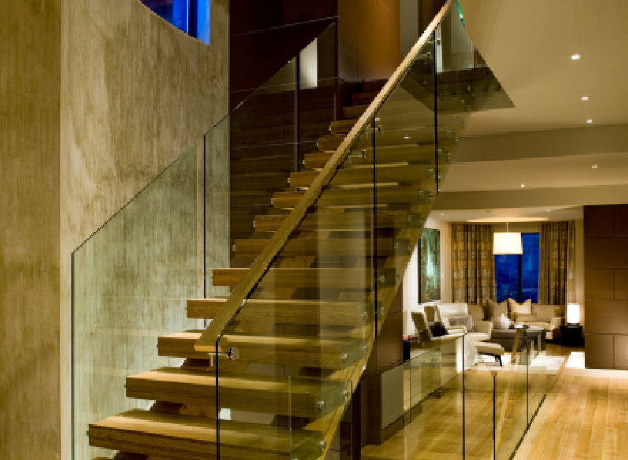 This stunning property boasts a modern interior with a beautiful wooden staircase and glass railings.