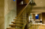 This stunning property boasts a modern interior with a beautiful wooden staircase and glass railings.