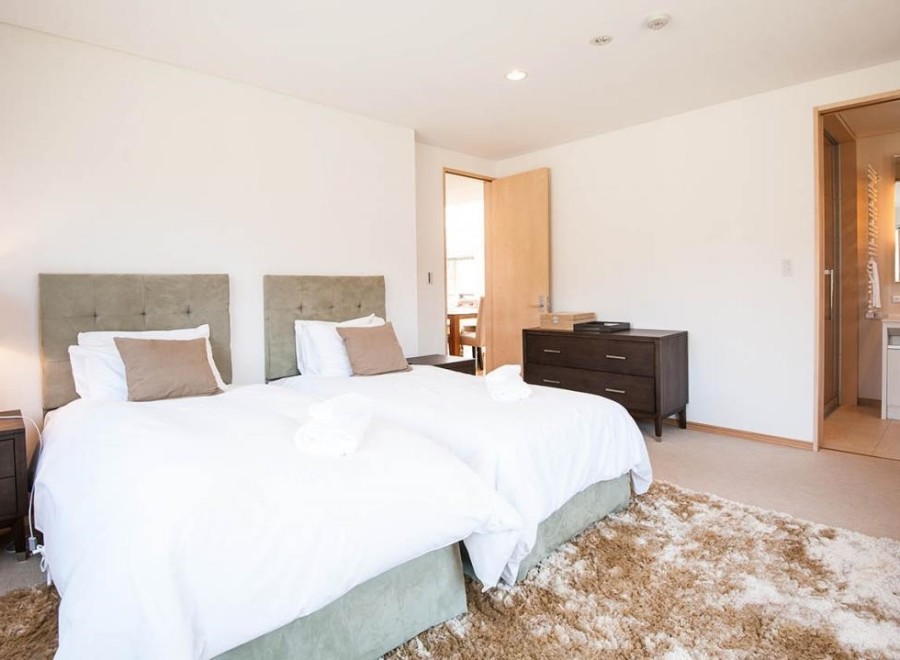 This bright and airy bedroom features twin beds with plush bedding, perfect for a relaxing stay.