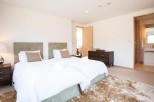 This bright and airy bedroom features twin beds with plush bedding, perfect for a relaxing stay.