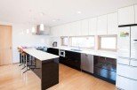 This stunning kitchen boasts a sleek, modern design with white and black cabinetry, creating a sophisticated atmosphere.