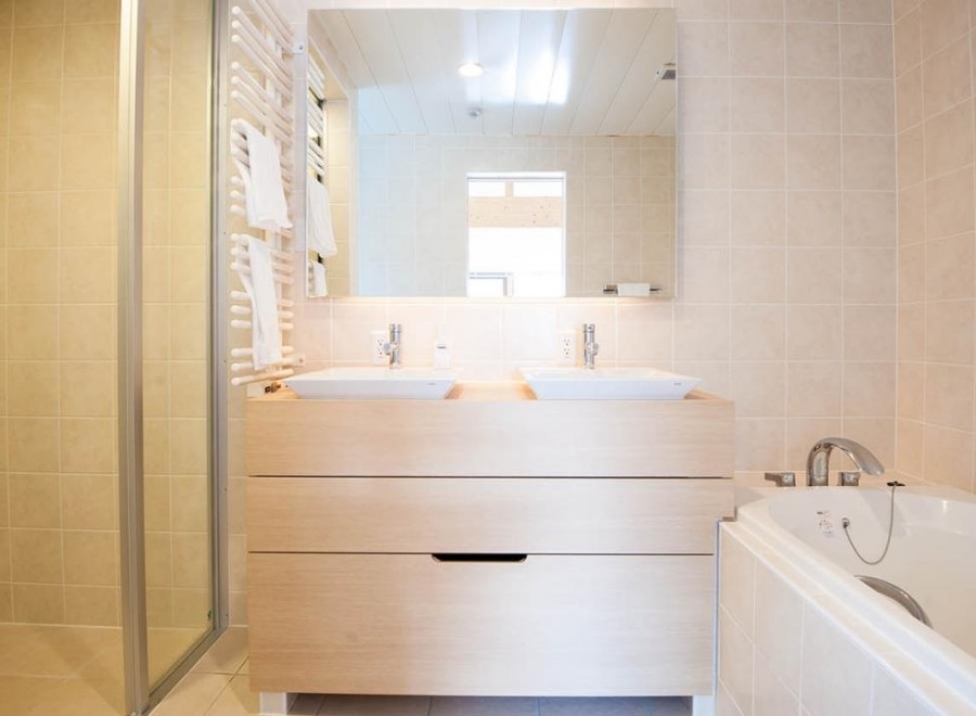 This luxurious bathroom boasts a double vanity with sleek sinks and ample storage, perfect for couples or families.