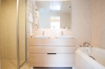 This luxurious bathroom boasts a double vanity with sleek sinks and ample storage, perfect for couples or families.