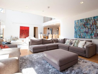 This stunning property boasts a spacious open-plan living area with floor-to-ceiling windows, allowing ample natural light to flood the room.