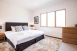 This bright and airy bedroom features a comfortable king-size bed with plush bedding, perfect for a relaxing stay.