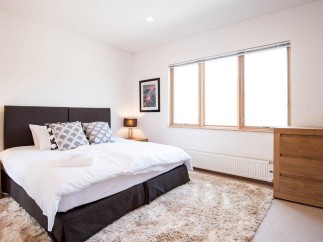 This bright and airy bedroom features a comfortable king-size bed with plush bedding, perfect for a relaxing stay.