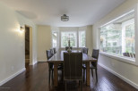 Elegant dining room with a large wooden table and comfortable leather chairs.
