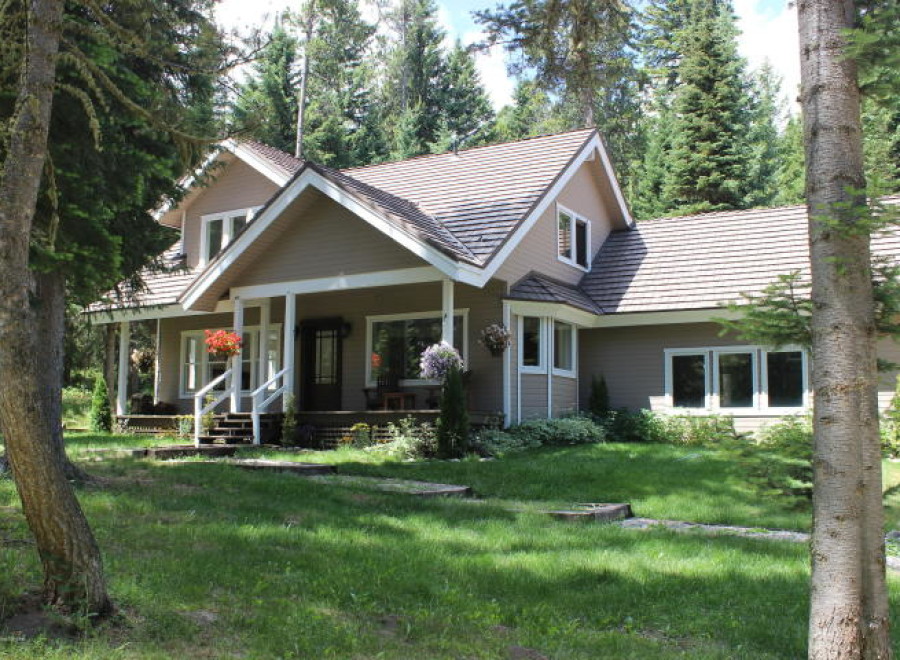 Nestled amidst lush greenery, this charming home boasts a welcoming porch and a classic design.