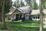 Nestled amidst lush greenery, this charming home boasts a welcoming porch and a classic design.