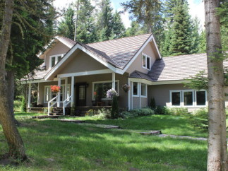 Nestled amidst lush greenery, this charming home boasts a welcoming porch and a classic design.