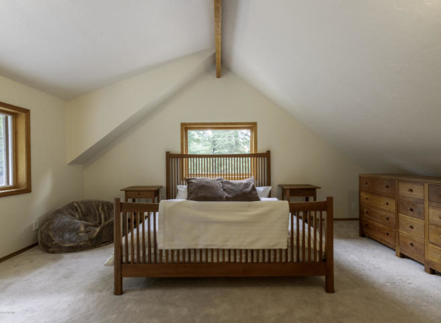 This cozy bedroom features a charming wooden bed frame and matching nightstands, creating a warm and inviting atmosphere.