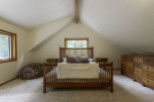 This cozy bedroom features a charming wooden bed frame and matching nightstands, creating a warm and inviting atmosphere.