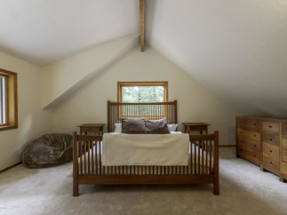 This cozy bedroom features a charming wooden bed frame and matching nightstands, creating a warm and inviting atmosphere.