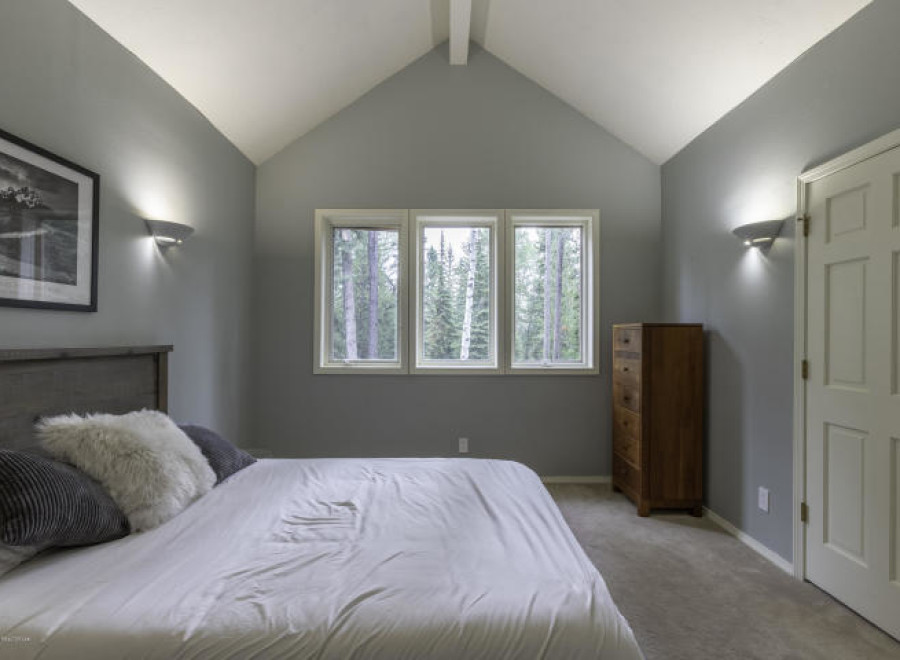 Discover a serene bedroom retreat with a vaulted ceiling and ample natural light.