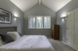 Discover a serene bedroom retreat with a vaulted ceiling and ample natural light.