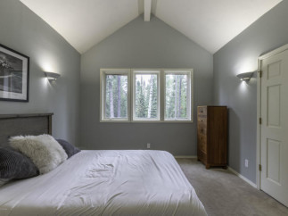Discover a serene bedroom retreat with a vaulted ceiling and ample natural light.