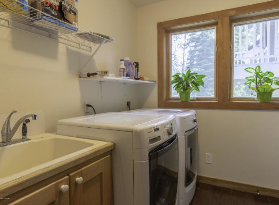 This laundry room features a convenient sink and ample counter space, perfect for tackling laundry day.