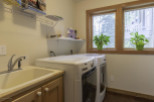 This laundry room features a convenient sink and ample counter space, perfect for tackling laundry day.