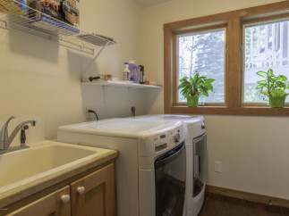 This laundry room features a convenient sink and ample counter space, perfect for tackling laundry day.