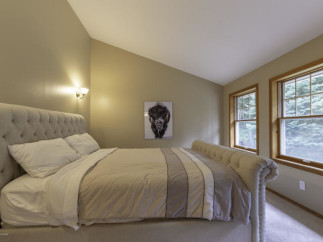 Discover the charm of this inviting bedroom, featuring a cozy bed and a stylish design.