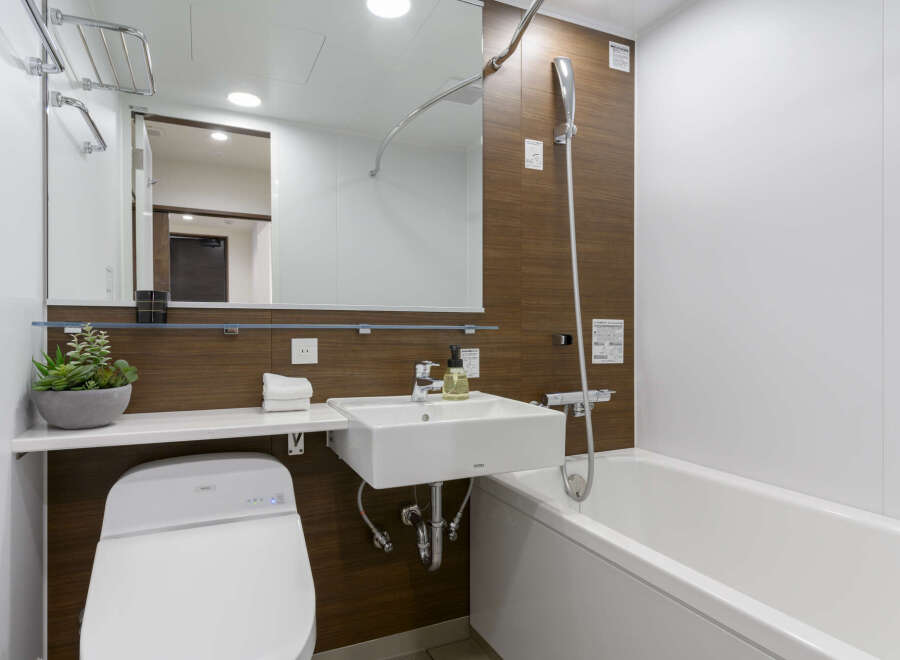 Modern bathroom with a sleek, white bathtub and toilet.
