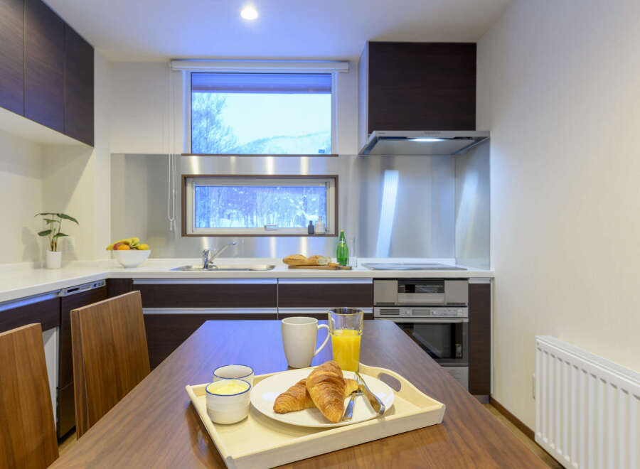 Modern kitchen with stainless steel appliances and wooden cabinetry.