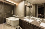Luxurious bathroom with a freestanding bathtub, double vanity, and glass shower enclosure.