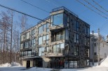 This modern building features a unique diamond-patterned facade, large windows offering ample natural light, and multiple balconies.