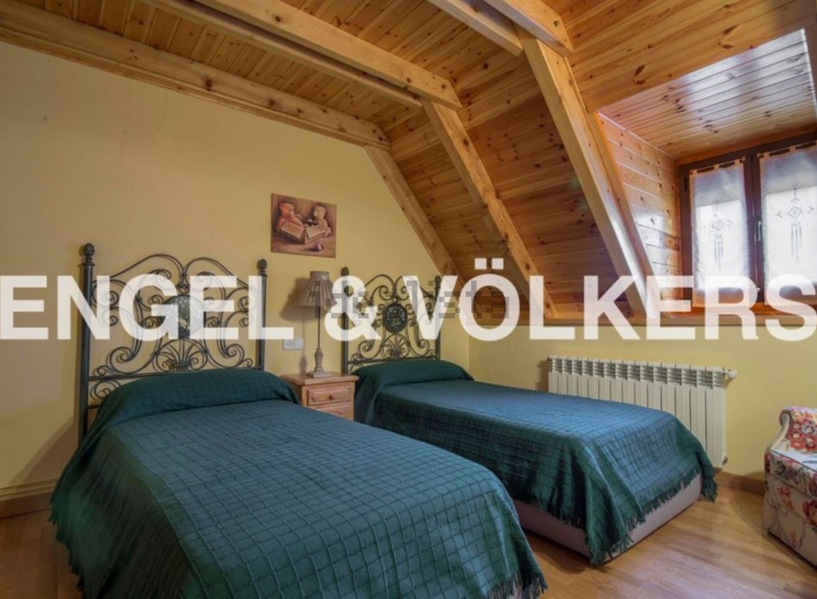 Charming attic bedroom with twin beds, wooden beams, and a cozy atmosphere.