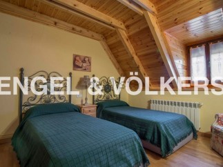 Charming attic bedroom with twin beds, wooden beams, and a cozy atmosphere.