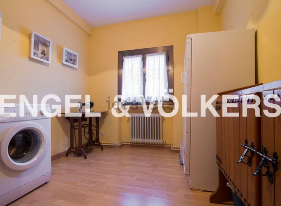 Charming laundry room with vintage sewing machine and ample storage.