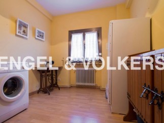 Charming laundry room with vintage sewing machine and ample storage.