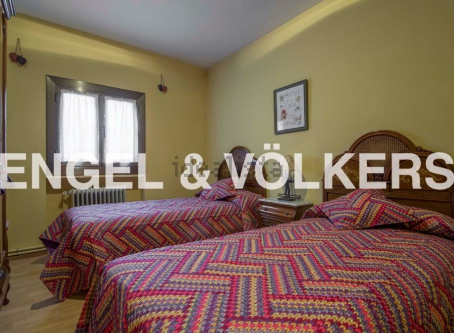 Charming twin bedroom with colorful bedding and wooden headboards.