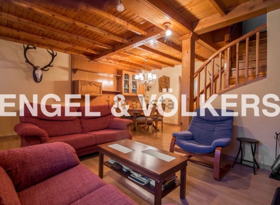 Rustic mountain chalet with wooden beams and a cozy living room.