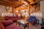 Rustic mountain chalet with wooden beams and a cozy living room.