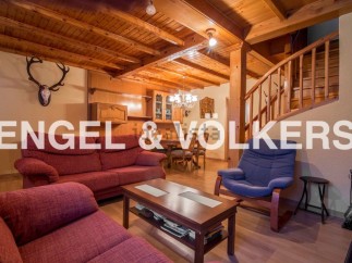 Rustic mountain chalet with wooden beams and a cozy living room.